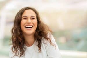 Woman with curly hair with a nice smile because of Endodontic Root Canal