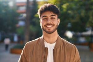 Smiling young man outdoors wearing casual jacket enjoying sunny day at Dental Services at Westlake Village Dental