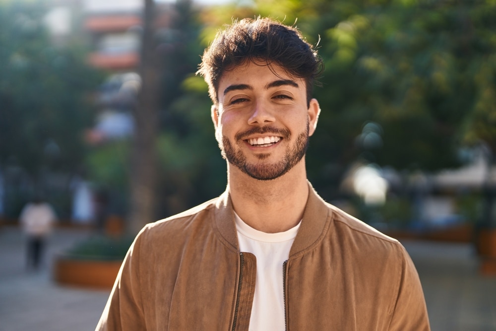 Smiling young man outdoors wearing casual jacket enjoying sunny day at Dental Services at Westlake Village Dental