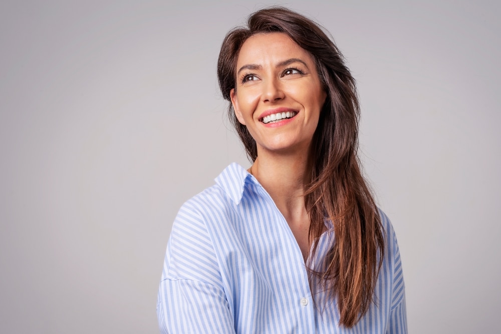 Smiling woman looking away happily in striped shirt at Dental Services at Westlake Village Dental