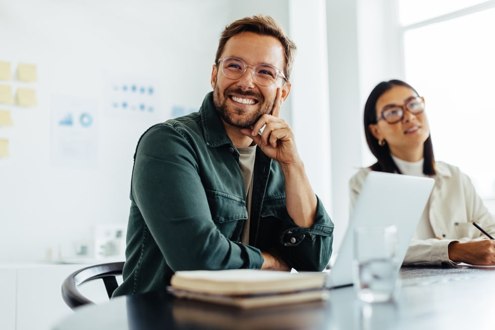 Man smiling while on a meeting for Straighten While You Work With Invisalign