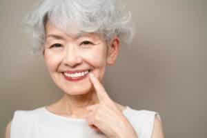 Smiling elderly woman with white hair posing happily indoors at Dental Services at Westlake Village Dental