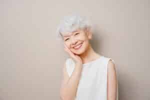 Smiling elderly woman with white hair posing happily indoors at Dental Services at Westlake Village Dental